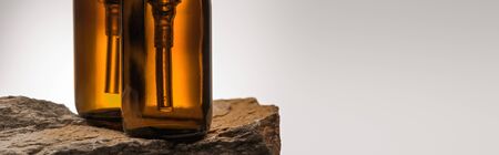 close up view of dispenser cosmetic bottles on stone on white background with back light, panoramic shotの写真素材