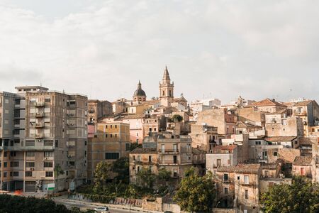 CATANIA, ITALY - OCTOBER 3, 2019: clock tower of Saint Agatha cathedral near small houses near trees in italyのeditorial素材