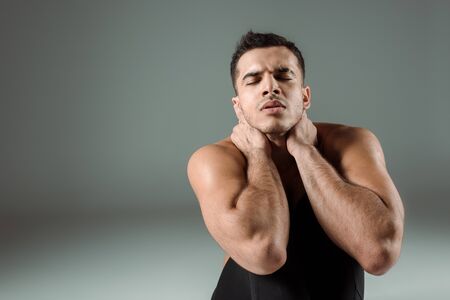 handsome dancer with closed eyes dancing contemporary on grey backgroundの写真素材