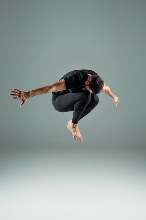dancer in black leggings and t-shirt dancing contemporary on dark backgroundの写真素材