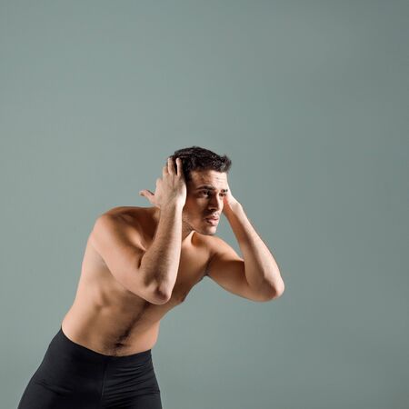 handsome dancer in black leggings dancing contemporary isolated on grey