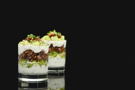 selective focus of fresh granola with kiwi and yogurt isolated on blackの写真素材