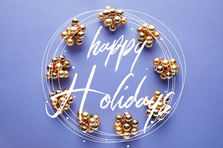 round frame of shiny golden Christmas decoration on blue background with Happy holidays letteringの写真素材