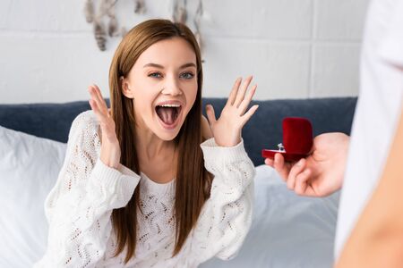 cropped view of man doing marriage proposal to shocked womanの写真素材