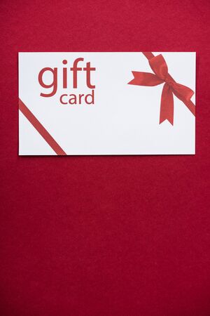 Top view of white gift card on red surfaceの写真素材