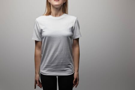 cropped view of woman in blank basic white t-shirt on grey backgroundの写真素材