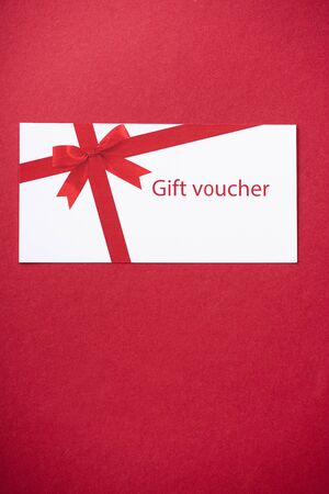 Top view of gift voucher on red background with copy spaceの写真素材