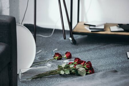 flowers and broken vase on floor in robbed apartmentの写真素材