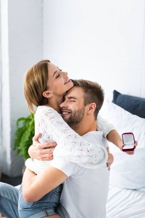 handsome man hugging smiling woman with engagement ringの写真素材