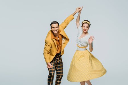 happy dancers holding hands while dancing boogie-woogie on grey backgroundの写真素材