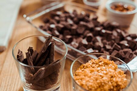 selective focus of chocolate sticks in glass near chocolate cubesの写真素材