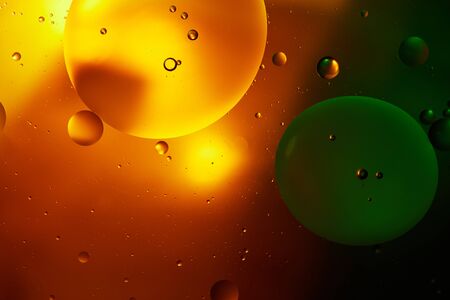 abstract background from mixed water and oil in orange and green color