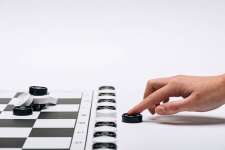 Cropped view of woman holding black checker by checkerboard on white background