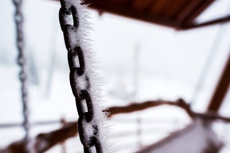 close up view of frozen chain covered with ice of swingの写真素材