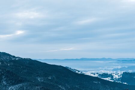 Scenic view of snowy mountains and cloudy skyの写真素材