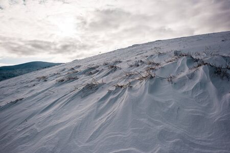 Scenic view of snowy hill with cloudy skyの写真素材