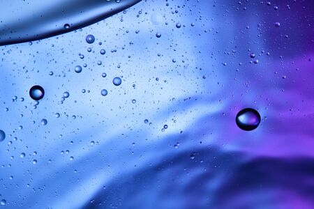 Beautiful abstract background from mixed water and oil in blue and purple colorの写真素材