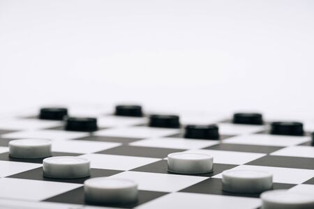 Selective focus of checkers on chessboard isolated on whiteの写真素材
