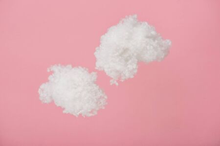white fluffy clouds made of cotton wool isolated on pinkの写真素材