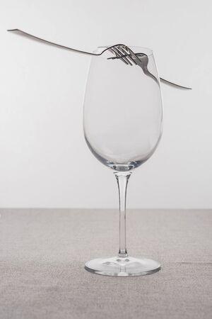 Forks on empty wine glass on tablecloth isolated on greyの写真素材