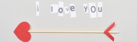 Top view of i love you lettering on papers with arrow on grey background, panoramic shot