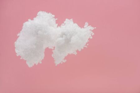 white fluffy cloud made of cotton wool isolated on pinkの写真素材