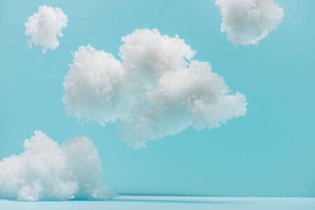 white fluffy clouds made of cotton wool isolated on blueの写真素材