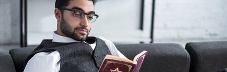 panoramic shot of handsome jewish man in glasses reading tanakhの写真素材
