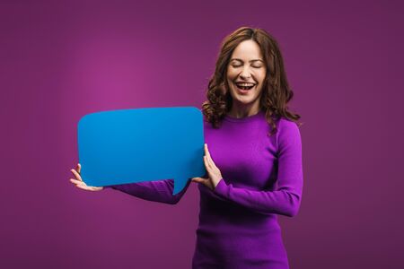 laughing woman holding speech bubble on purple background