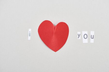Top view of i love you lettering with heart shaped paper on grey backgroundの写真素材