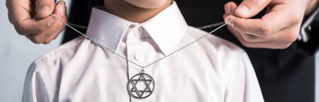 panoramic shot of jewish father wearing star of david necklace on sonの写真素材