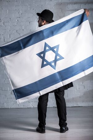 back view of jewish man with flag of israelの写真素材