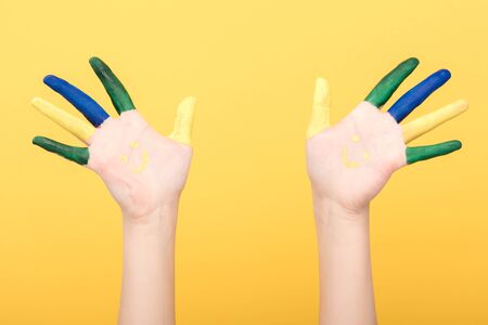 cropped view of woman showing colorful fingers isolated on yellowの写真素材