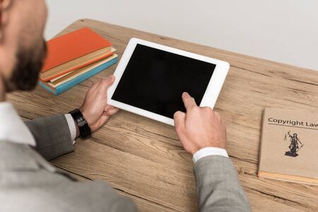 partial view of businessman holding digital tablet with blank screen isolated on grey