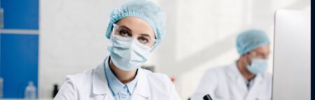panoramic shot of genetic consultant looking at camera in lab