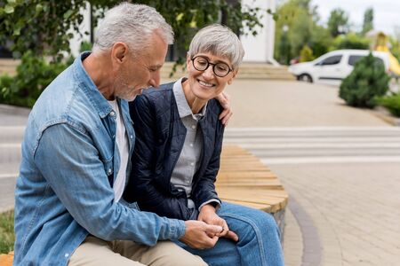 mature man hugging smiling woman and holding handsの写真素材