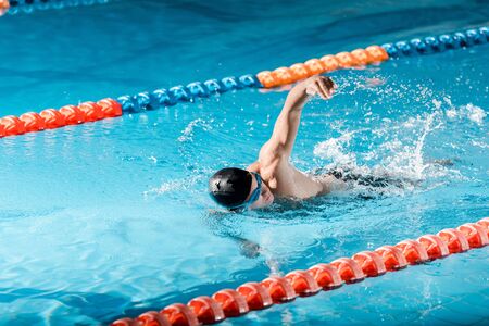 handsome swimmer training in swimming poolの写真素材