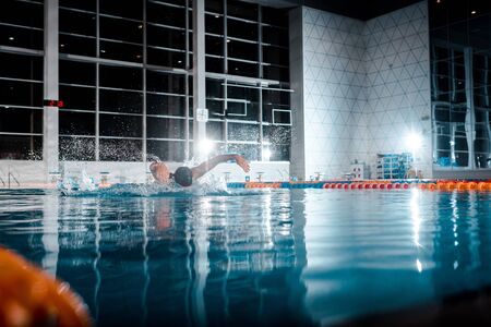 selective focus of sportsman swimming butterfly stroke in swimming poolの写真素材