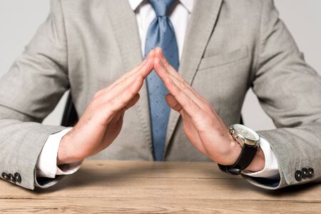 cropped view of businessman showing protection gesture isolated on greyの写真素材