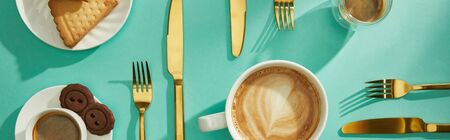 Top view of coffee with delicious cookies and cutlery on turquoise background, panoramic shotの写真素材