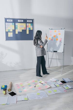 scrum master standing in modern office near sticky notes on floor