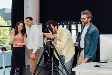 photographer taking photo near art director in glasses and assistantsの写真素材