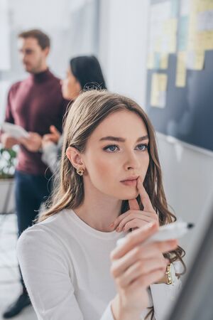 selective focus of attractive scrum master touching lips near coworkersの写真素材