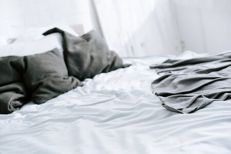 selective focus of blanket on bed with grey pillowsの写真素材