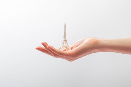 cropped view of woman holding small eiffel tower statuette isolated on whiteの写真素材