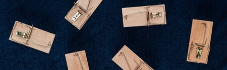 top view of wooden mousetraps on blue background, panoramic shot