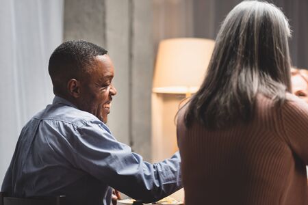 back view of african american man and woman smiling during dinner