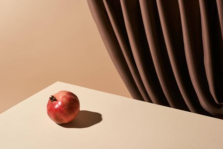 classic still life with pomegranate on table near curtain isolated on beigeの写真素材