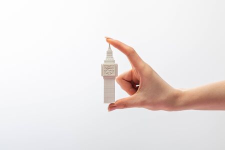 cropped view of woman holding small big ben tower figurine isolated on white