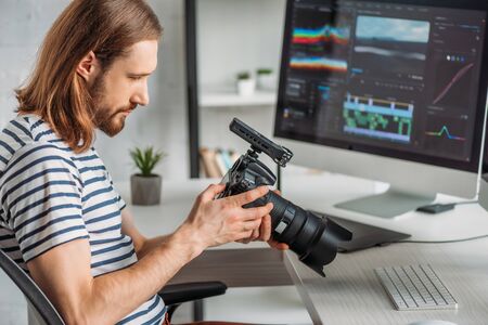 side view of editor holding digital camera